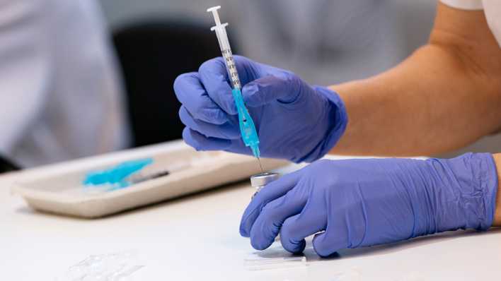 Medizinische Fachkraft beim befüllen einer Spritze mit dem AstraZeneca-Impfstoff