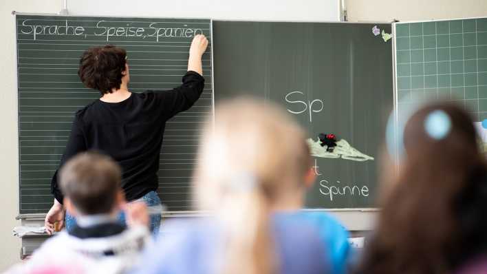 Eine Lehrerin schreibt in einer Grundschule Wörter mit «Sp» am Anfang an eine Tafell