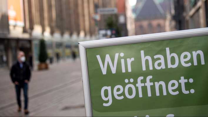 Auf einem Schild in der Bremer Innenstadt steht "Wir haben geöffnet" (Bild: dpa)