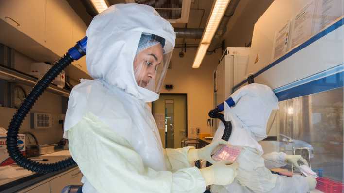 Eine Wissenschaftlerin ält eine Multiwellplatte mit vom Coronavirus infizierten Zellkulturen in einem Labor der biologischen Sicherheitsstufe 3 (Hochsicherheitslabor) im Helmholtz-Zentrum für Infektionsforschung HZI. (Bild: picture alliance/dpa | Julian Stratenschulte)