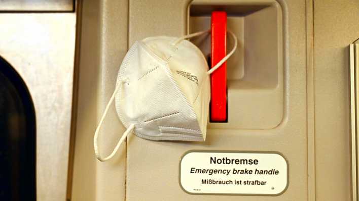 Symbolbild Notbremse: Notbremse im Zug mit einer FFP2-Maske (Bild: picture alliance)