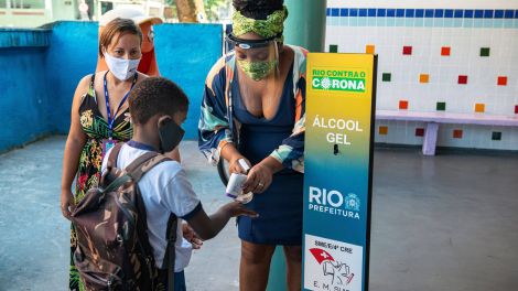 Ein Schüler in Rio de Janeiro desinfiziert seine Hände vor dem Betreten einer Schule (Bild: IMAGO / Penta Press)