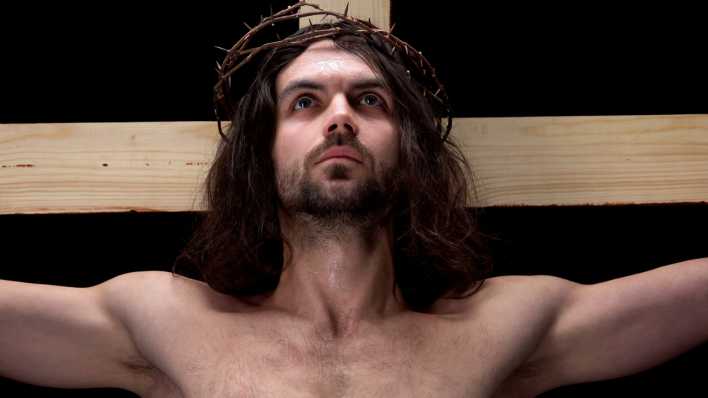 Ein Jesus-Darsteller am Kreuz mit Dornenkrone guckt selbstbewusst hinauf (Bild: colourbox)