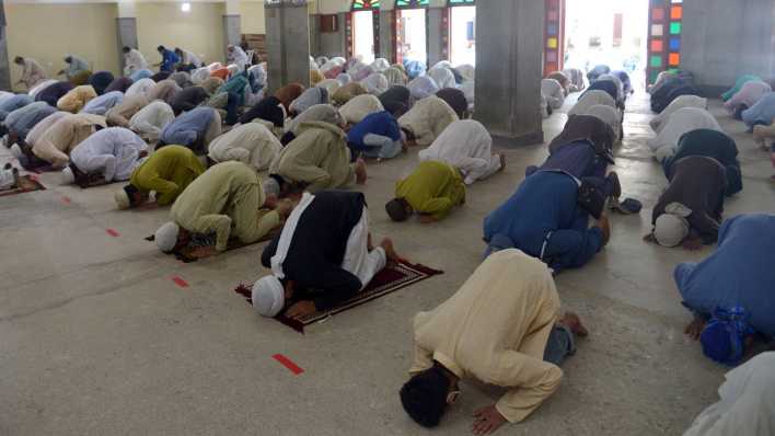 Muslime knien nach vorn gebeugt beim Gebet (Bild: picture alliance / Pacific Press)