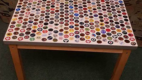 Eine Tischplatte, verziert mit vielen bunten Kronkorken
