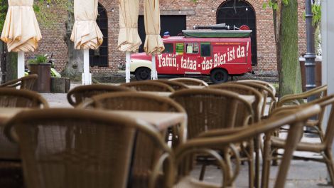 Leere Tische und Stühle stehen im Biergarten der Braumanufaktur im Potsdamer Forsthaus Templin unter einem Zeltdach vor zusammengeklappten Sonnenschirmen