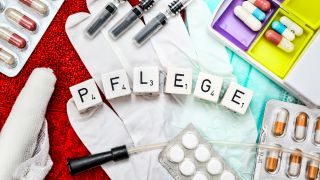 Symbolfoto Pflege: Latexhandschuhe, Tabletten und Pflege-Utensilien