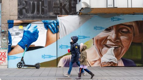 Ein Wandbild an einem leerstehenden Geschäftsgebäude in der Innenstadt von Bochum thematisiert die Coronakrise, Impfen und Freiheiten nach dem Impfen.