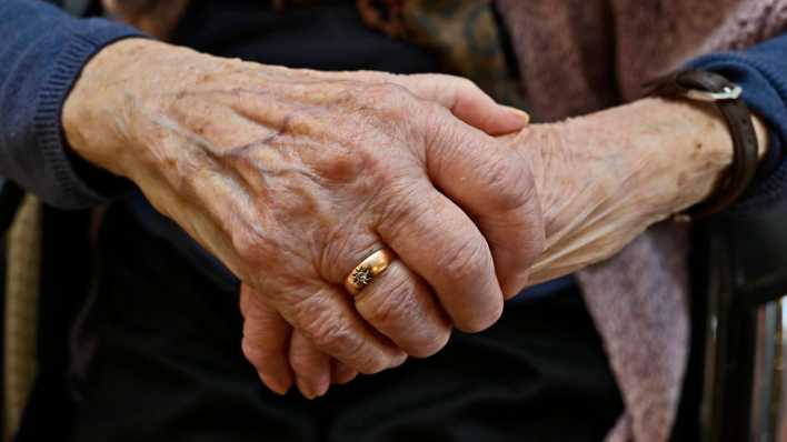 Hände einer Seniorin im Pflegeheim