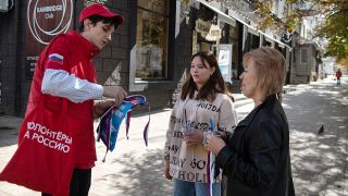 Ein Freiwilliger verteilt Informationsmaterial für das Referendum in Luhansk zum Beitritt Russlands