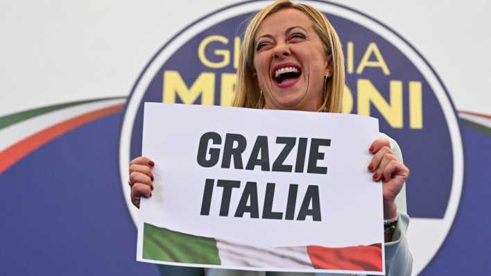 Giorgia Meloni (Fratelli d'Italia) hält nach der Parlamentswahl ein Schild mit der Aufschrift "Grazie Italia" (Danke Italien) (Bild: picture alliance / ANSA)