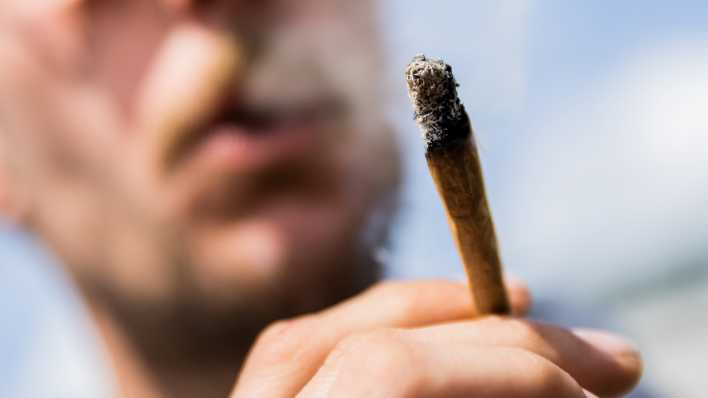 Ein Mann raucht einen Joint mit Medizinalcannabis