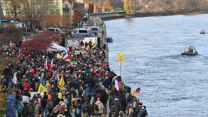 Viele Menschen nehmen am Ufer des deutsch-polnischen Grenzflusses Oder an einer Demonstration gegen Corona-Maßnahmen teil.