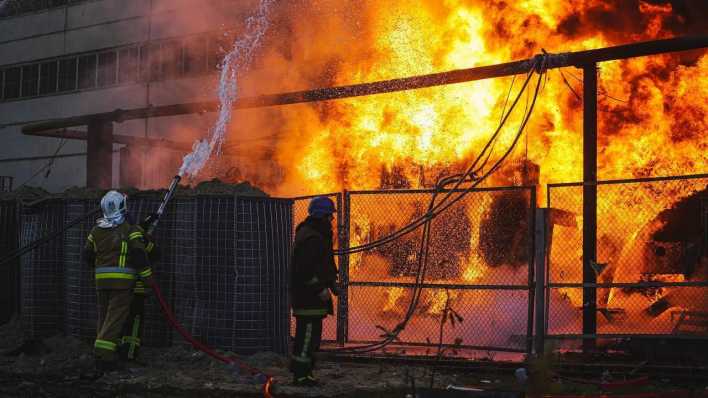 Rettungskräfte versuchen nach einem Angriff auf ein Energiekraftwerk in Kiew das Feuer zu löschen.