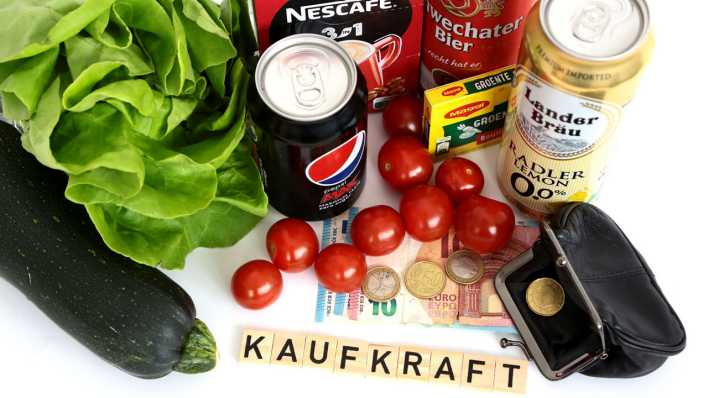 Das Wort "Kaufkraft" gelegt aus Buchstabensteinchen liegt neben Lebensmitteln und einer Geldbörse (Bild: picture alliance / PPE)
