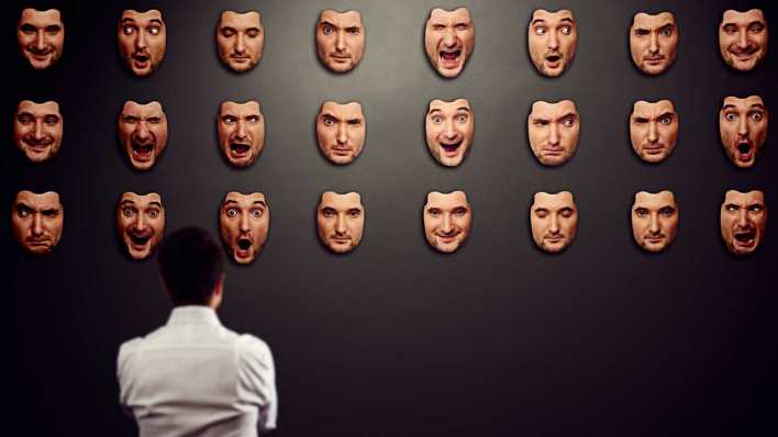 Sympolbild Persönlichkeitsstörung: Mann betrachtet viele Gesichtsmasken mit unterschiedlichen Mimiken (Bild: COLOURBOX)