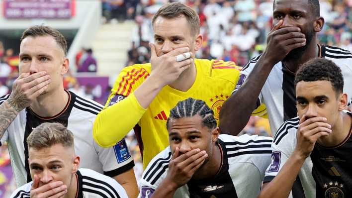 Die Spieler der deutschen Mannschaft halten vor dem Spiel die Hände vor den Mund.