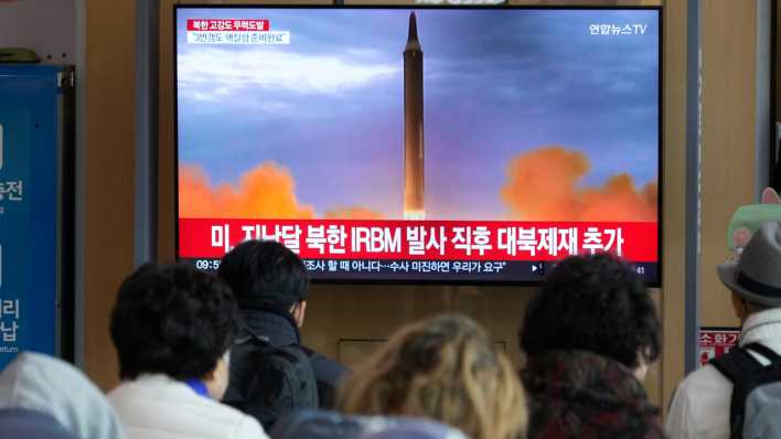 Menschen betrachten einen Fernseher in Seoul, auf dem ein Raketenstart in Nordkorea zu sehen ist.