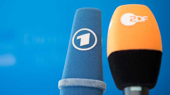 Die Mikrofone von ARD und ZDF sind vor einer Pressekonferenz nebeneinander aufgestellt.