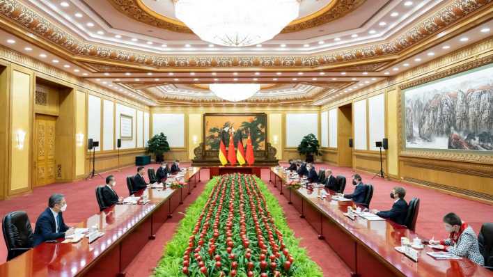Beim China-Besuch des Bundeskanzler sitzt die deutsche Delegation dem Chinesischen Präsidenten Xi Jinping und weiteren Mitgliedern der chinesischen Führung zu Gesprächen gegenüber.