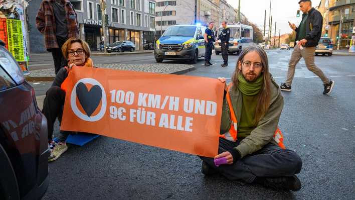 Mitglieder der Klimaprotestgruppe Letzte Generation blockieren am Berliner Schönhauser Tor eine Straße.