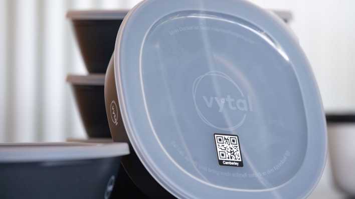 Mehrwegbehälter des Herstellers Vytal mit einem QR-Code sind bei einem Pressetermin ausgestellt.