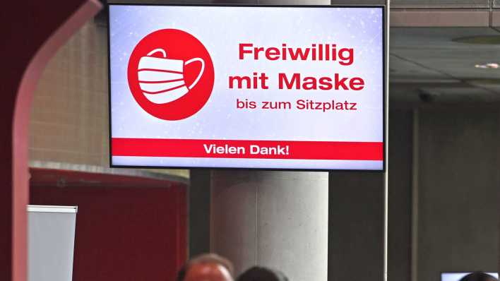 FREIWILLIG MIT MASKE - auf einem Monitor im Foyer eines Kinos werden die Besucher angehalten, Masken bis zum Sitzplatz zu tragen