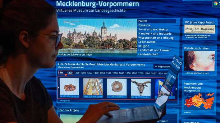 Eine Frau schaut sich von zu Hause aus die Internetseiten des Virtuellen Landesmuseum Mecklenburg-Vorpommern an (Bild: picture alliance/dpa/dpa-Zentralbild)