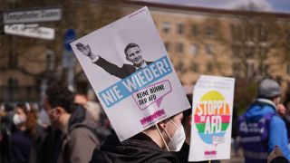 Ein Transparent mit der Aufschrift "stoppt die AfD" und ein Transparent mit einem Bernd Höcke, der den rechten Arm zum Hitlergruß ausstreckt und dem Wortlaut "Nie wieder", sind bei einer Demonstration linker und linksradikaler Gruppen in Berlin zu sehen.