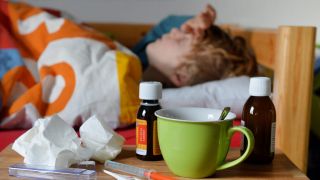 Symbolbild: Kranker Junge im Bett mit Medizin