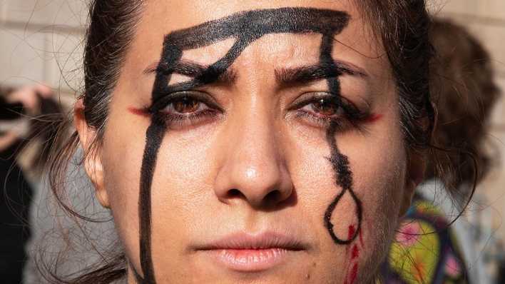 Eine Frau hat einen Galgen auf ihr Gesicht gemalt, um während einer Demonstration in Barcelona an die Ermordung von Mohsen Shekari zu erinnern.