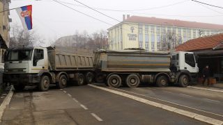 Eine Straßenbarrikade aus mit Steinen beladenen Lastwagen