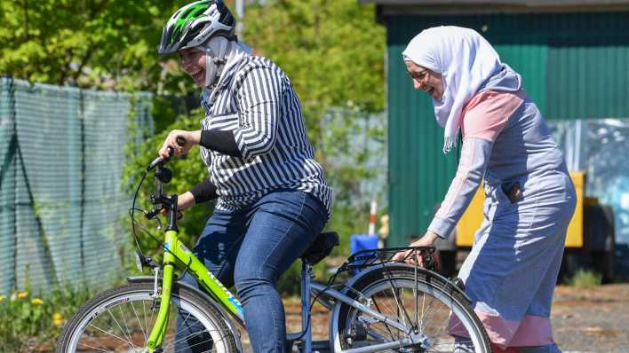 Eine arabische Frau lernt das Fahrradfahren auf dem Gelände der Verkehrswacht.