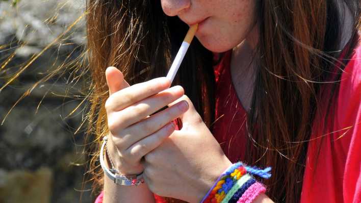 Symbolbild: Eine Jugendliche zündet sich eine Zigarette an