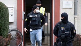 Bei einer Razzia gegen sogenannte "Reichsbürger" stehen Polizisten vor einem durchsuchten Objekt in Frankfurt.