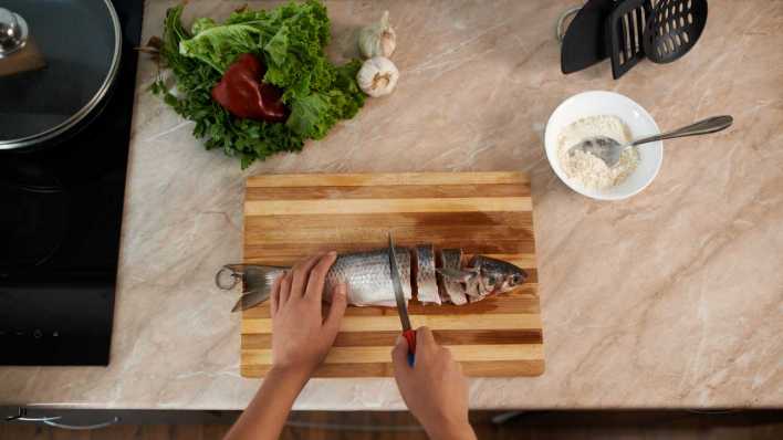 Zubereitung von Fisch und Salat (Bild: COLOURBOX)