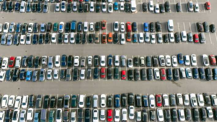Parkplatz mit Autos von Mitarbeitern an der Tesla Gigafactory in Gruenheide