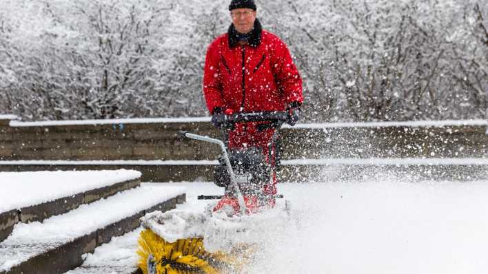 Schnee - Ein Mann räumt in Cottbus einen Weg vor einem Grundstück (Bild: dpa)