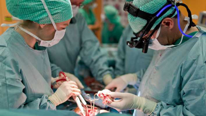 Professor Rene Pretre, Chefarzt Chirurgie am Kinderspital Zuerich, haelt waehrend einer Herztransplantation an einem 7-jaehrigen Kind das neue, gesunde Herz in der Hand.