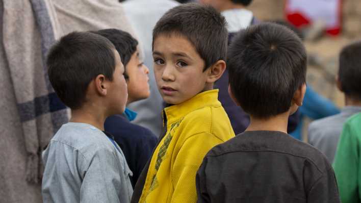 Kinder in einem Waisenhaus in der Provinz Bamyan in Afghanistan warten in einer Schlange auf Kleiderspenden