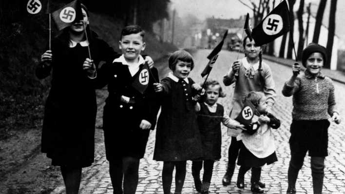 Kinder gehen mit Hakenkreuzfahnen in der Hand spazieren. Propagandafoto für die Presse (Bild: rbb/Scherl/Süddeutsche Zeitung Photo)