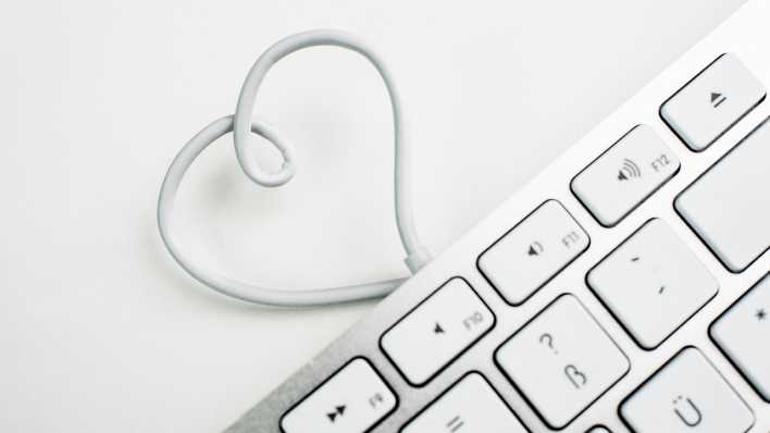 Das Kabel einer Computertastatur formt ein Herz. (Quelle: Picture Alliance)