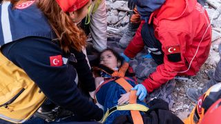 Rettungskräfte und Sanitäter bergen in der Türkei eine Person aus einem eingestürzten Gebäude (Bild: dpa)