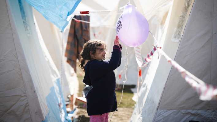 Ein Kind spielt in einem Zeltlager für Erdbebenopfer mit einem Luftballon.