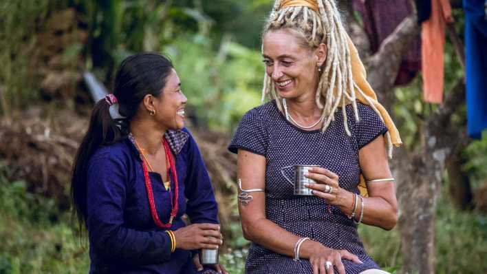Back-to-Life-Mitgründerin Stella Deetjen (rechts) und eine Frau trinken im Chitwan-Distrikt in Nepal Tee und unterhalten sich.