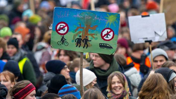 Zahlreiche Menschen mit Schildern und Transparenten nehmen am Freitag in Berlin an der Kundgebung von Fridays for Future teil.