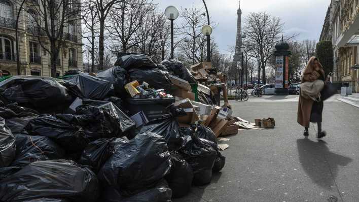 Paris: Eine Frau geht an einem nicht abgeholten Müllhaufen vorbei