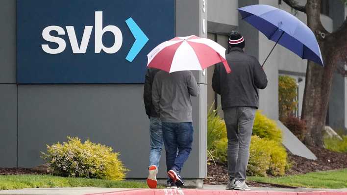 Menschen gehen an einem Schild der Silicon Valley Bank (SVB) am Hauptsitz des Unternehmens vorbei. (Bild: dpa)