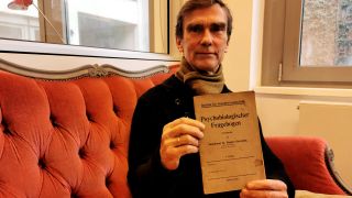 Der Autor Reiner Herrn hält ein altes Dokument in der Hand, auf dem steht: "Istitut für Sexualwissenschaft - Psychologihscer Fragebogen" (Bild: rbb/ Matthias Schirmer)