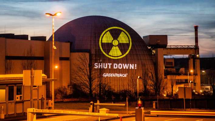 Bei einer Greenpeace-Aktion gegen Atomkraft haben Aktivisten mit Hilfe eines großen Projektors ein Symbol für Strahlung und die Worte "Shut down!" auf das Kernkraftwerk Neckarwestheim projiziert.